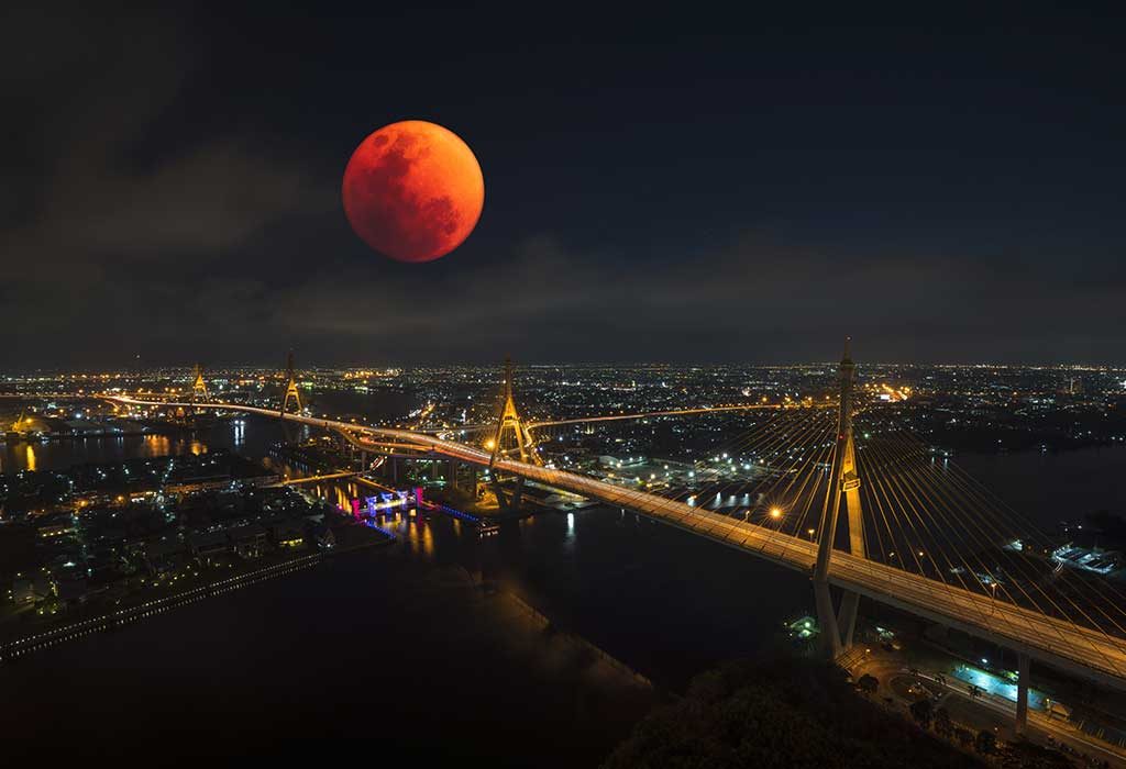 bulan darah terlihat di atas kota yang ramai