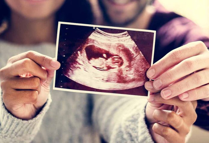 pasangan menunjukkan gambar USG setelah mengkonfirmasi kehamilan