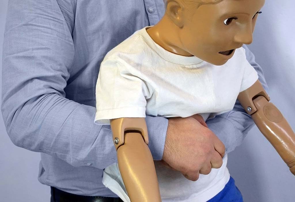 sukarelawan mendemonstrasikan teknik dorong perut untuk tersedak pada anak-anak