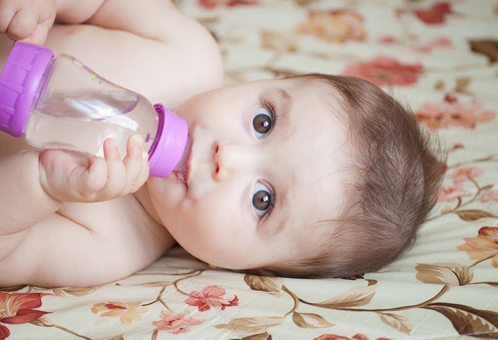 Seorang bayi minum air melalui botol