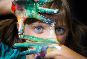 Seorang gadis kecil dengan tangannya diolesi cat air