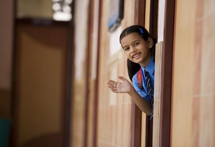 Seorang gadis kecil mengenakan seragam sekolahnya