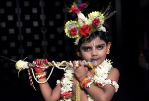 Seorang anak kecil berpakaian seperti Dewa Krishna