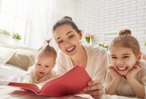 Seorang ibu dengan senang hati membacakan untuk anak