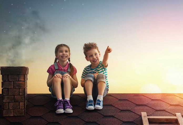 anak laki-laki dan perempuan menonton langit bersama di atap