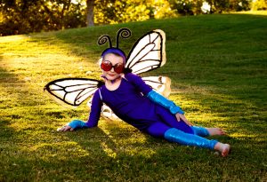 Seorang gadis kecil mengenakan kostum kupu-kupu