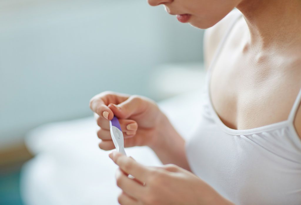 wanita memegang tes kehamilan