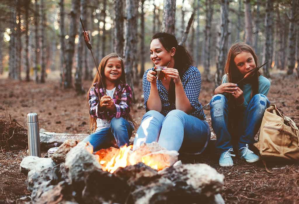 Ibu dan anak perempuan menikmati api unggun