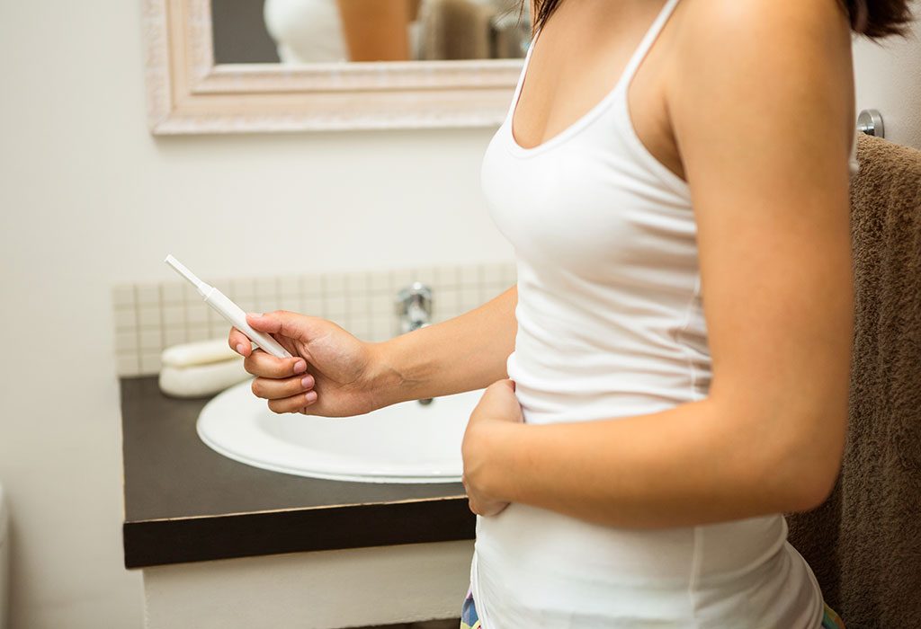 Wanita melakukan tes kehamilan di kamar mandi