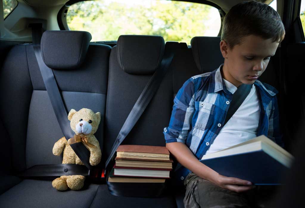 anak duduk tegak dengan sabuk pengaman di dalam mobil