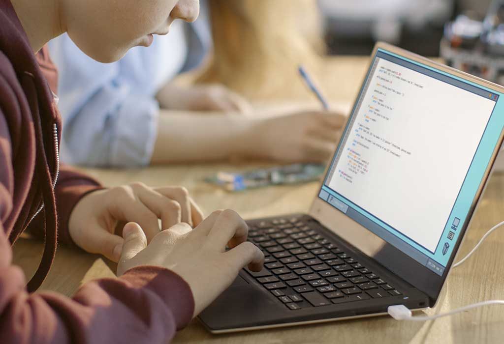 Seorang anak sekolah yang sedang mengerjakan laptop
