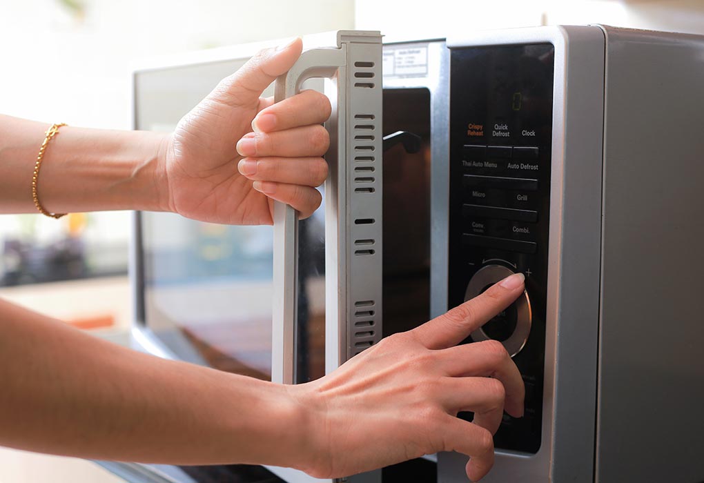 Seorang wanita menggunakan microwave