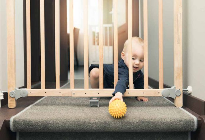 bayi mengambil bolanya melalui gerbang pengaman bayi
