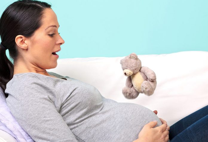 Seorang wanita hamil dengan tangan di perut
