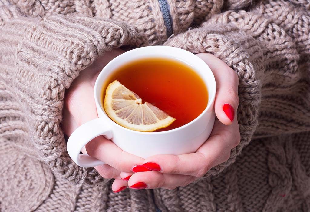 Wanita memegang teh lemon - obat musim dingin yang umum