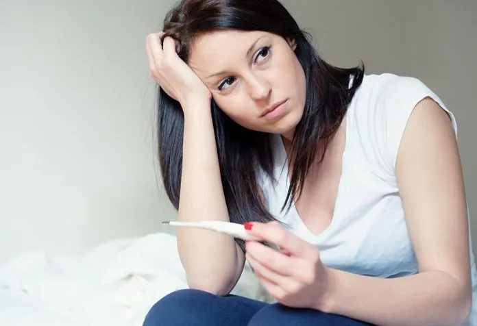 Seorang wanita yang putus asa dengan tongkat tes kehamilan