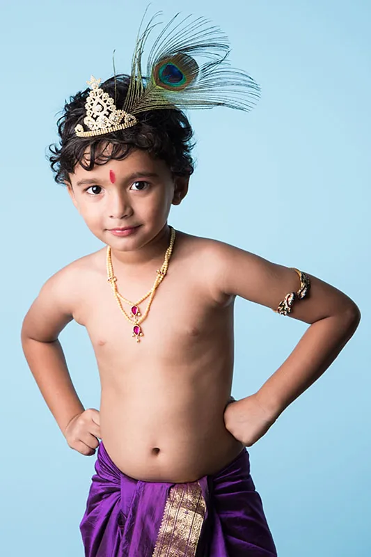 Seorang anak laki-laki berpakaian seperti Dewa Krishna