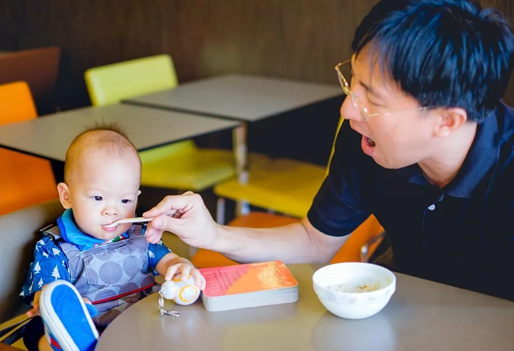 Seorang bayi makan bubur suji