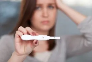 Wanita memegang tes kehamilan