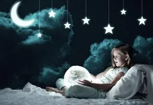Seorang gadis kecil memegang bola dunia yang bersinar dalam kegelapan