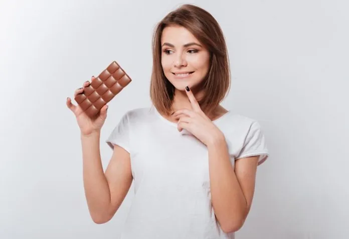 Seorang wanita berpikir tentang makan cokelat