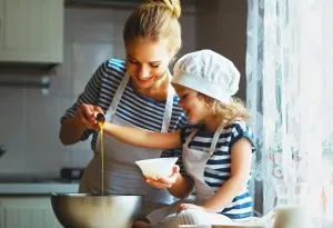 Seorang ibu dan anak perempuannya sedang memasak di dapur