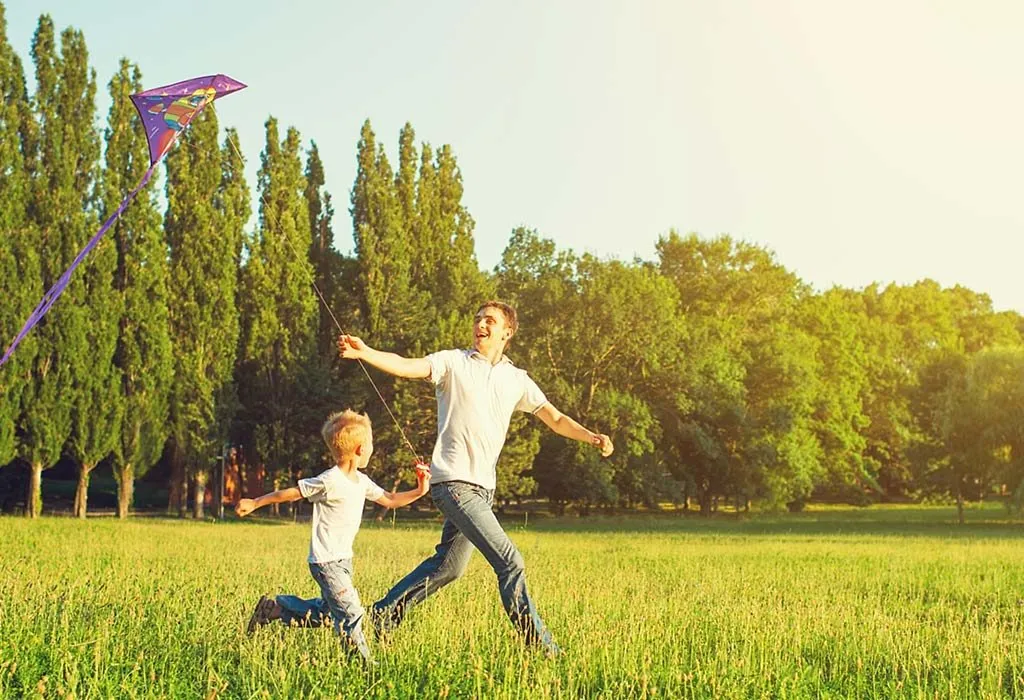 Seorang ayah dan anak menerbangkan layang-layang