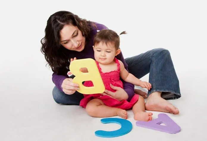 Seorang ibu mengajar huruf untuk bayinya