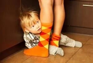 Anak canggung secara sosial bersembunyi di balik kaki ibu