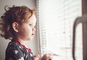 Bayi perempuan melihat ke luar jendela