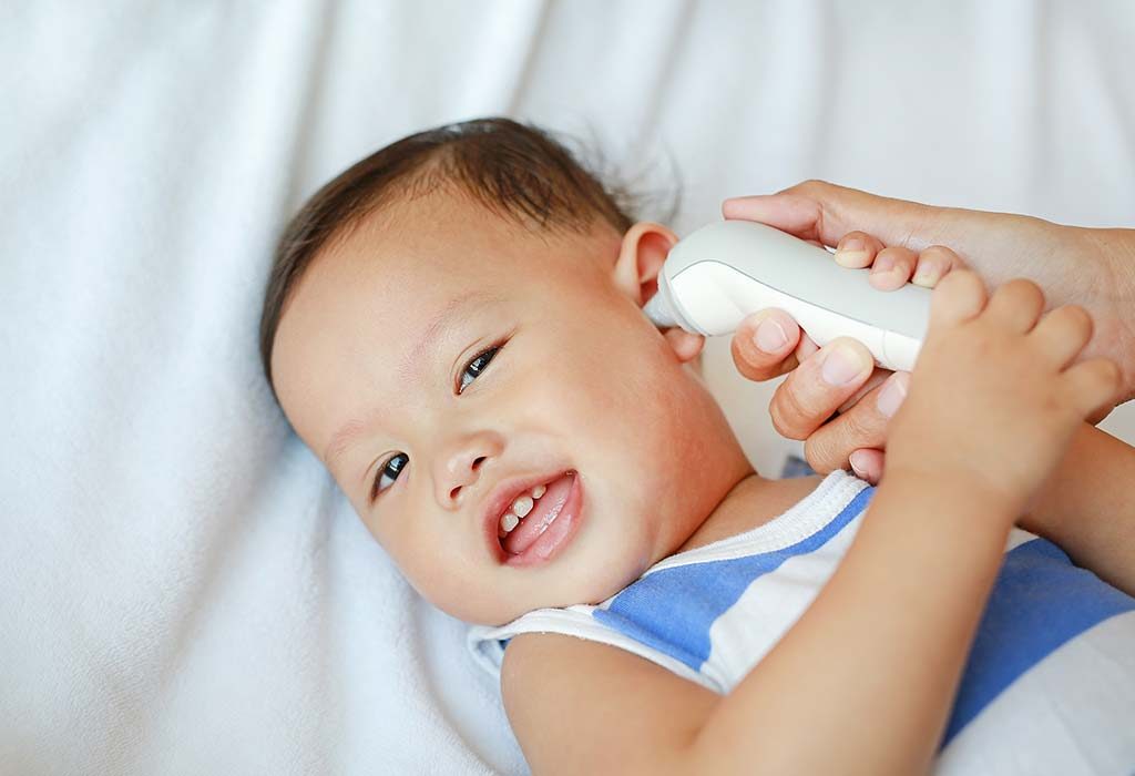 orang tua mengukur demam bayi menggunakan termometer telinga
