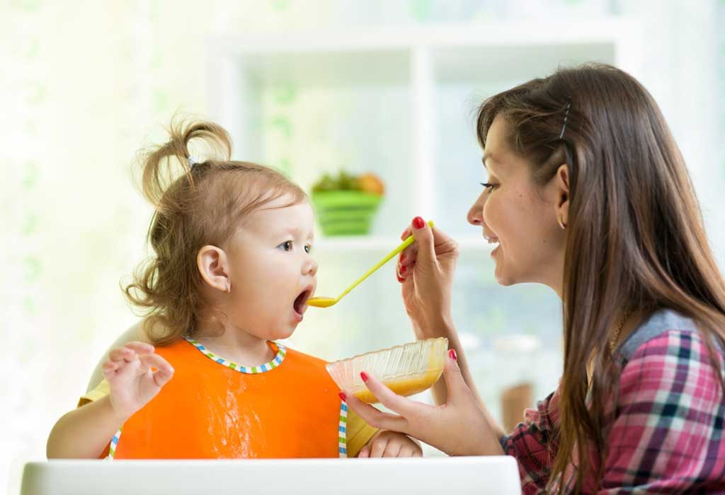 Seorang ibu memberi makan putrinya