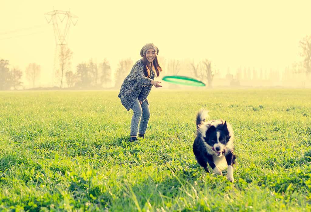 Seorang wanita bermain pergi menjemput dengan anjingnya