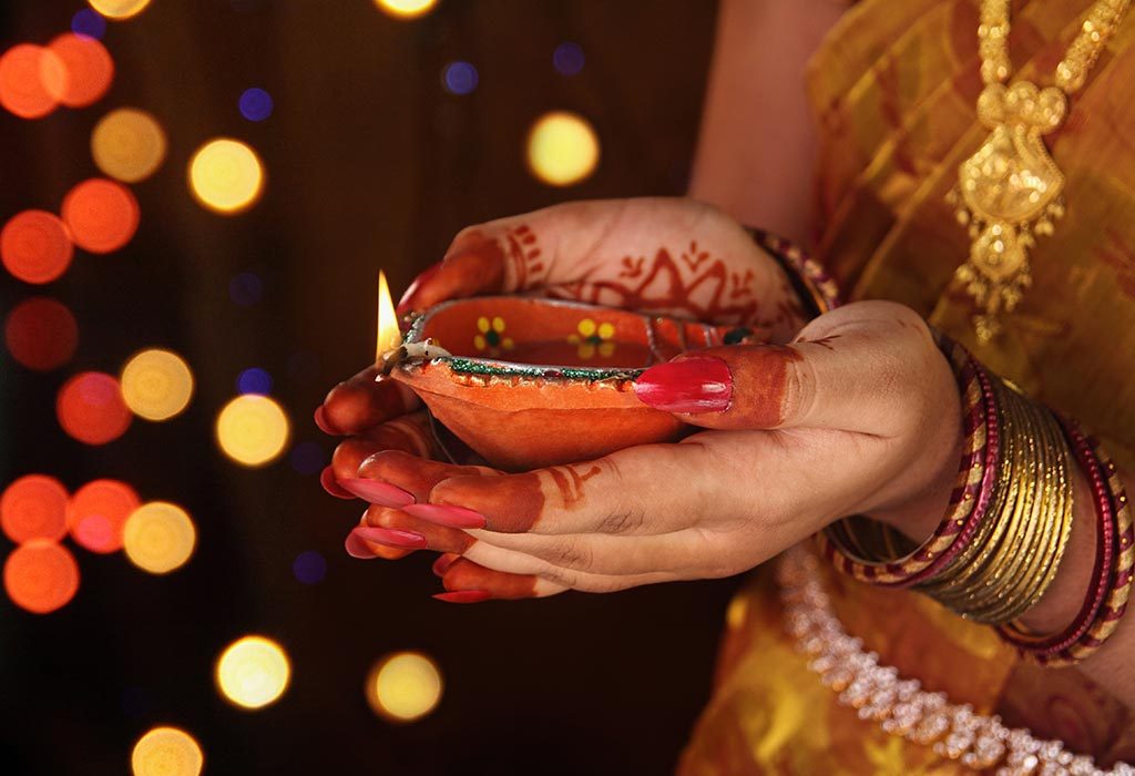 Wanita memegang Diwali diya