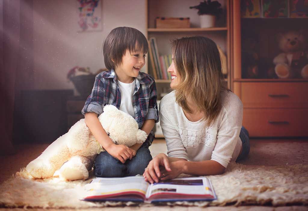 Seorang ibu muda membacakan buku untuk anaknya