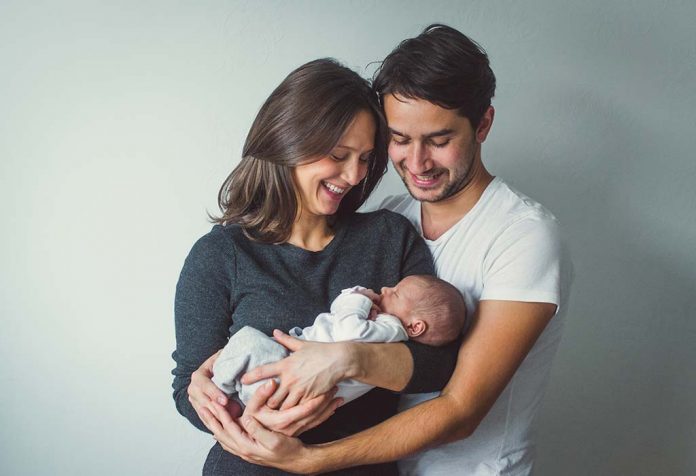 pasangan bahagia menggendong bayi mereka yang baru lahir