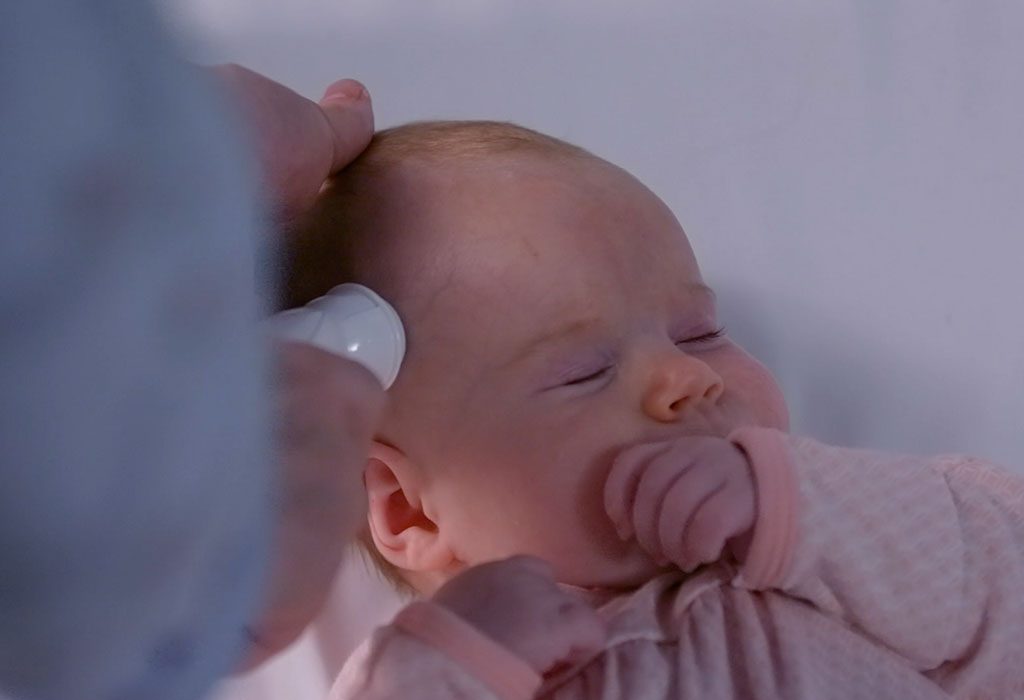 Seorang wanita memeriksa suhu bayinya dengan Termometer Arteri Temporal