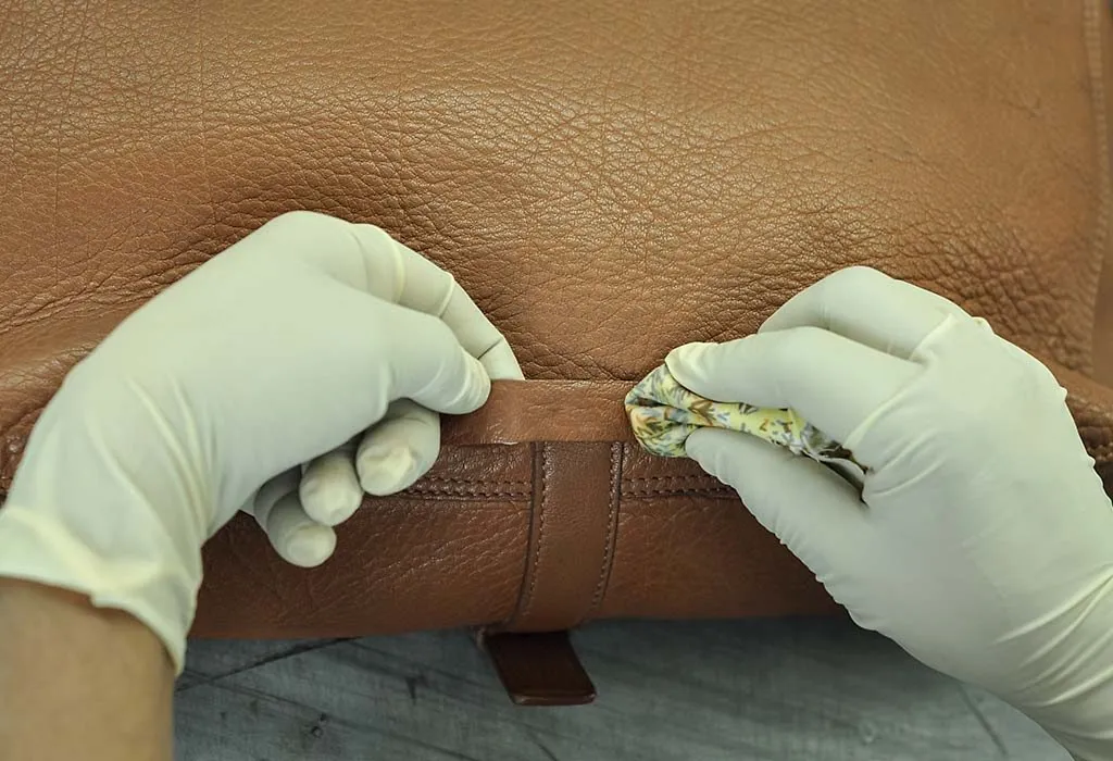 Sebuah tas kulit sedang dibersihkan oleh seorang profesional