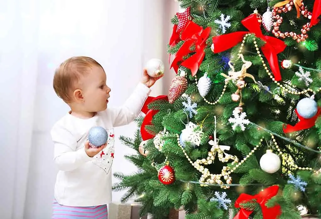bayi mendekorasi pohon natal